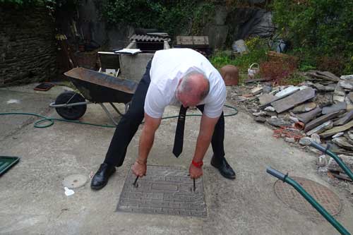 Neil Jasper lifting a drain cover for an inspection